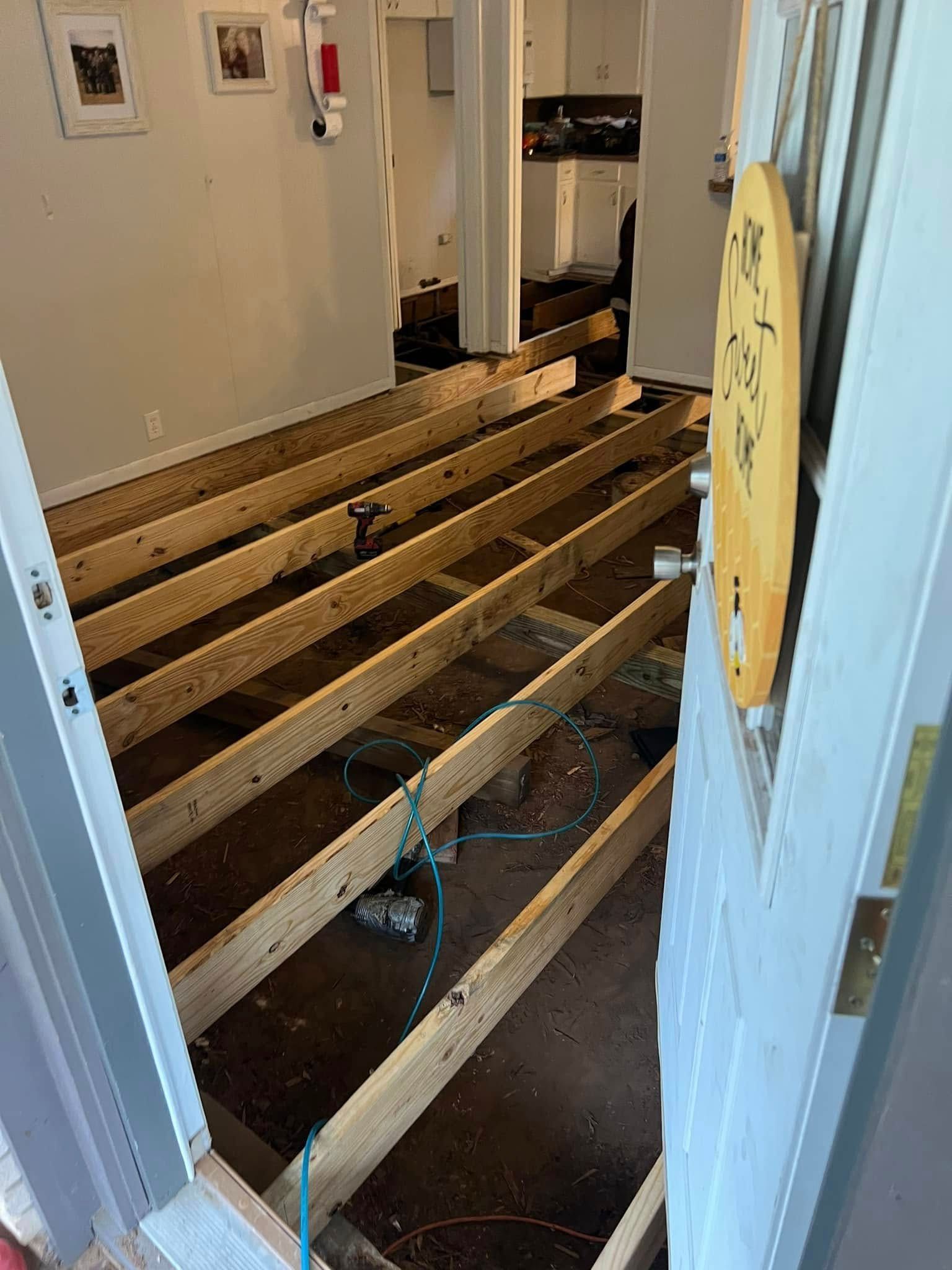 Exposed floor joists and insulation in a doorway during home renovation