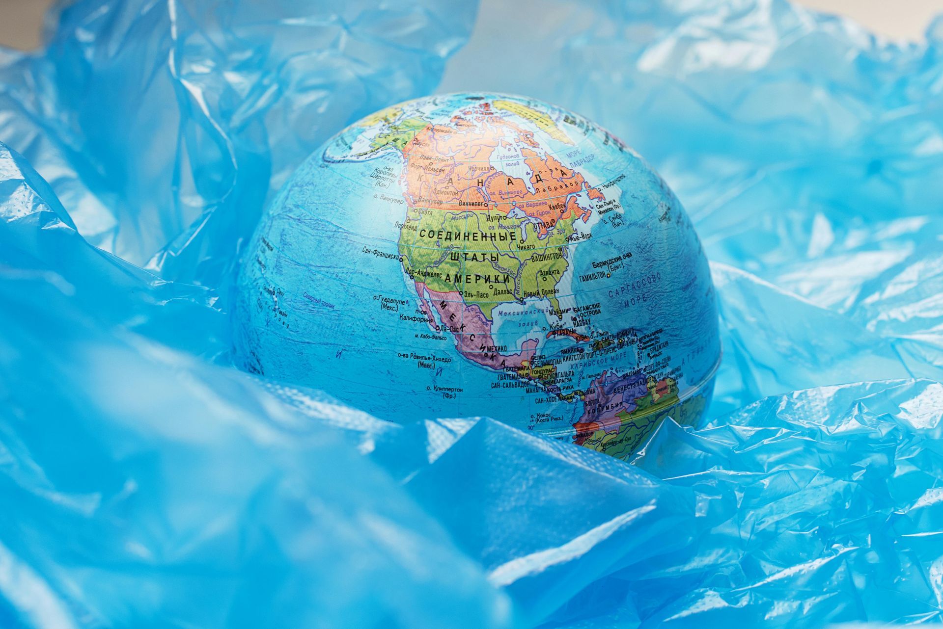 A small globe is sitting on top of a blue plastic bag.