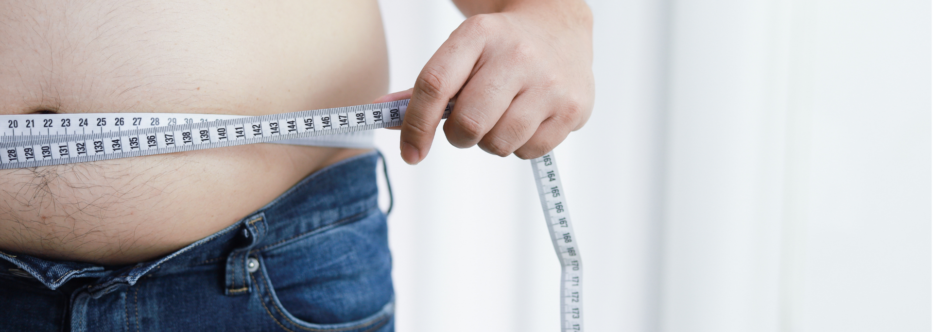 Picture of a person measuring their waist.