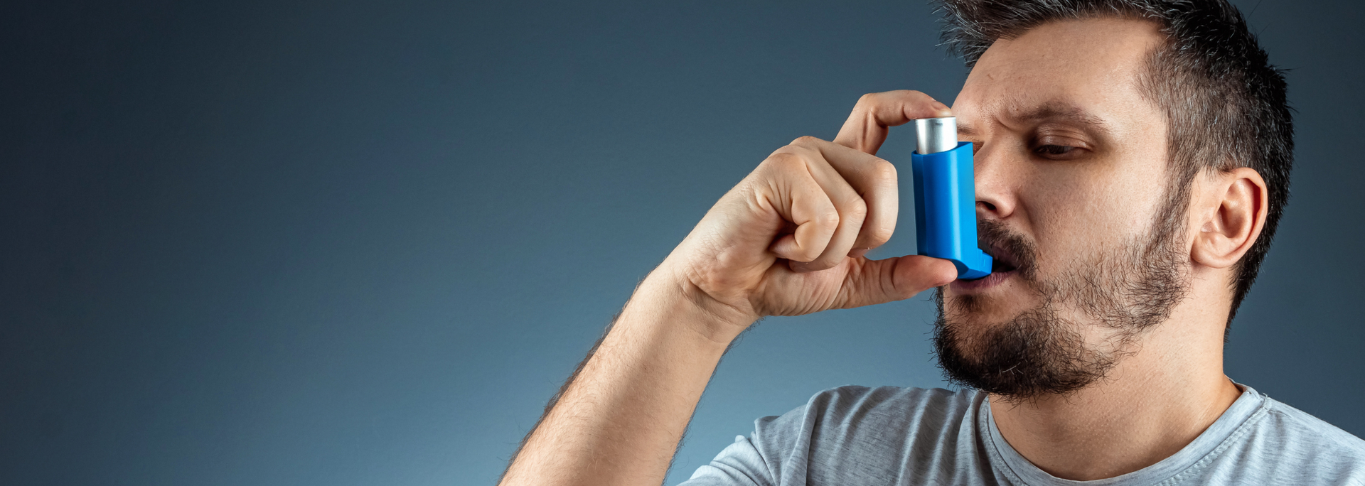 Picture of someone using an inhaler.