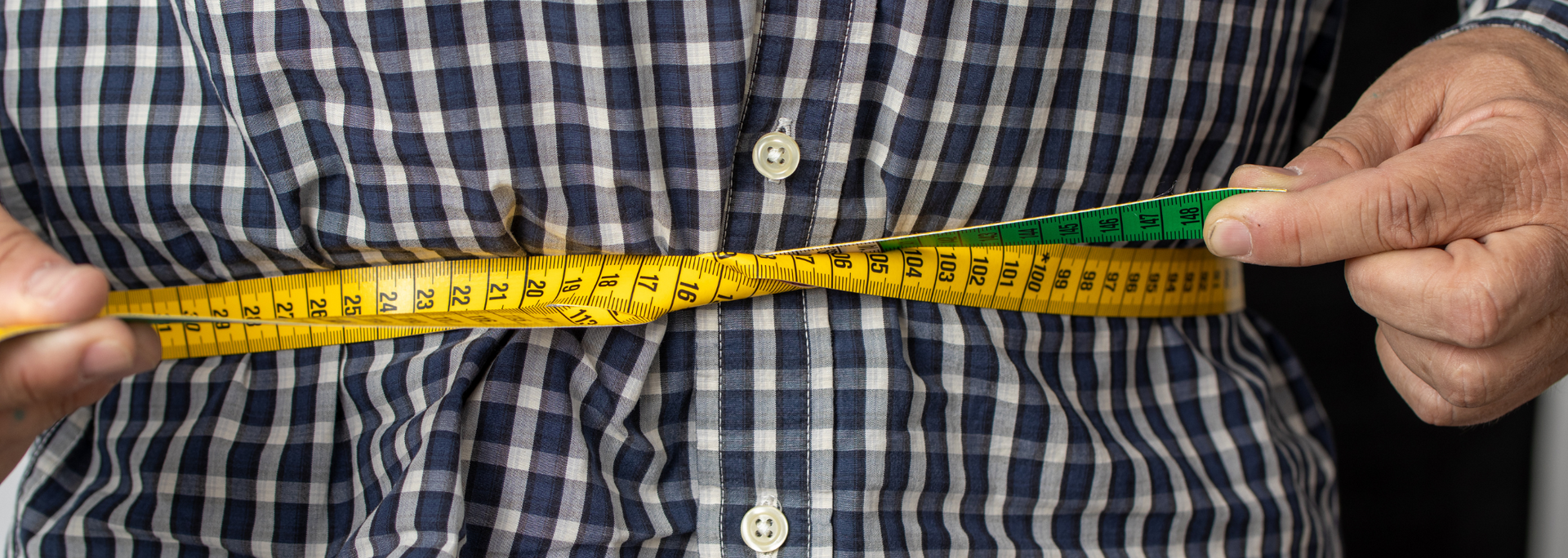 Picture of tape measure around a person's waist.
