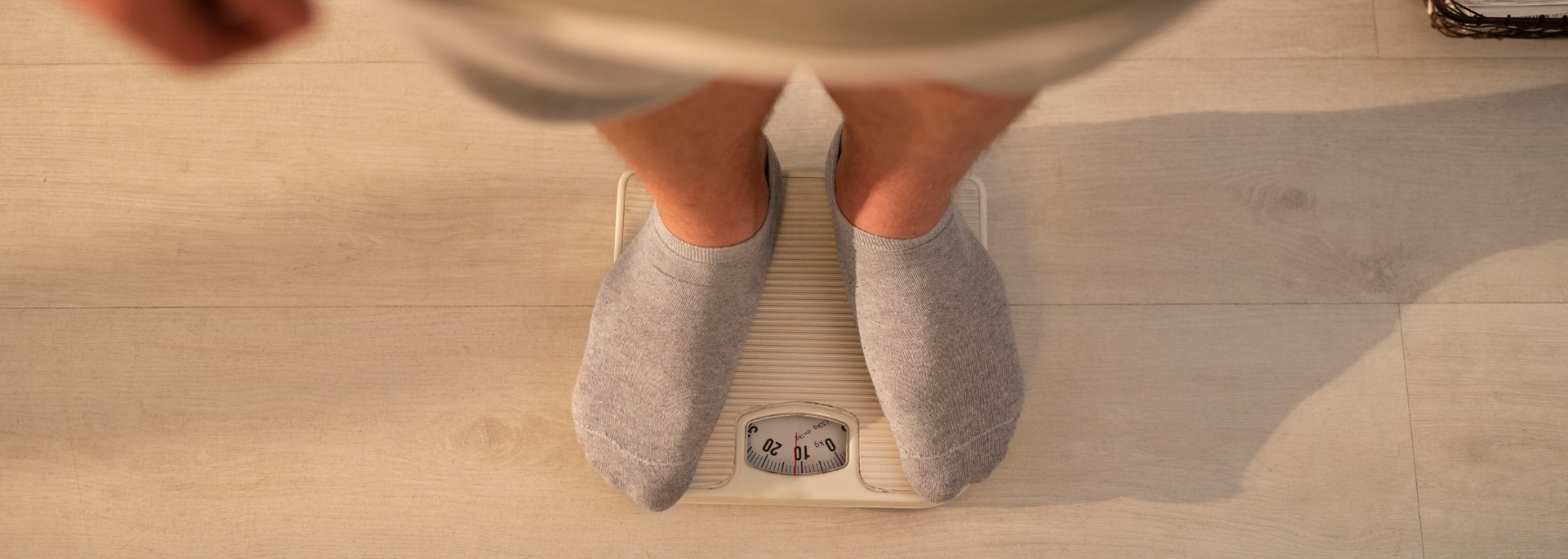 Picture of person's legs standing on body scale.