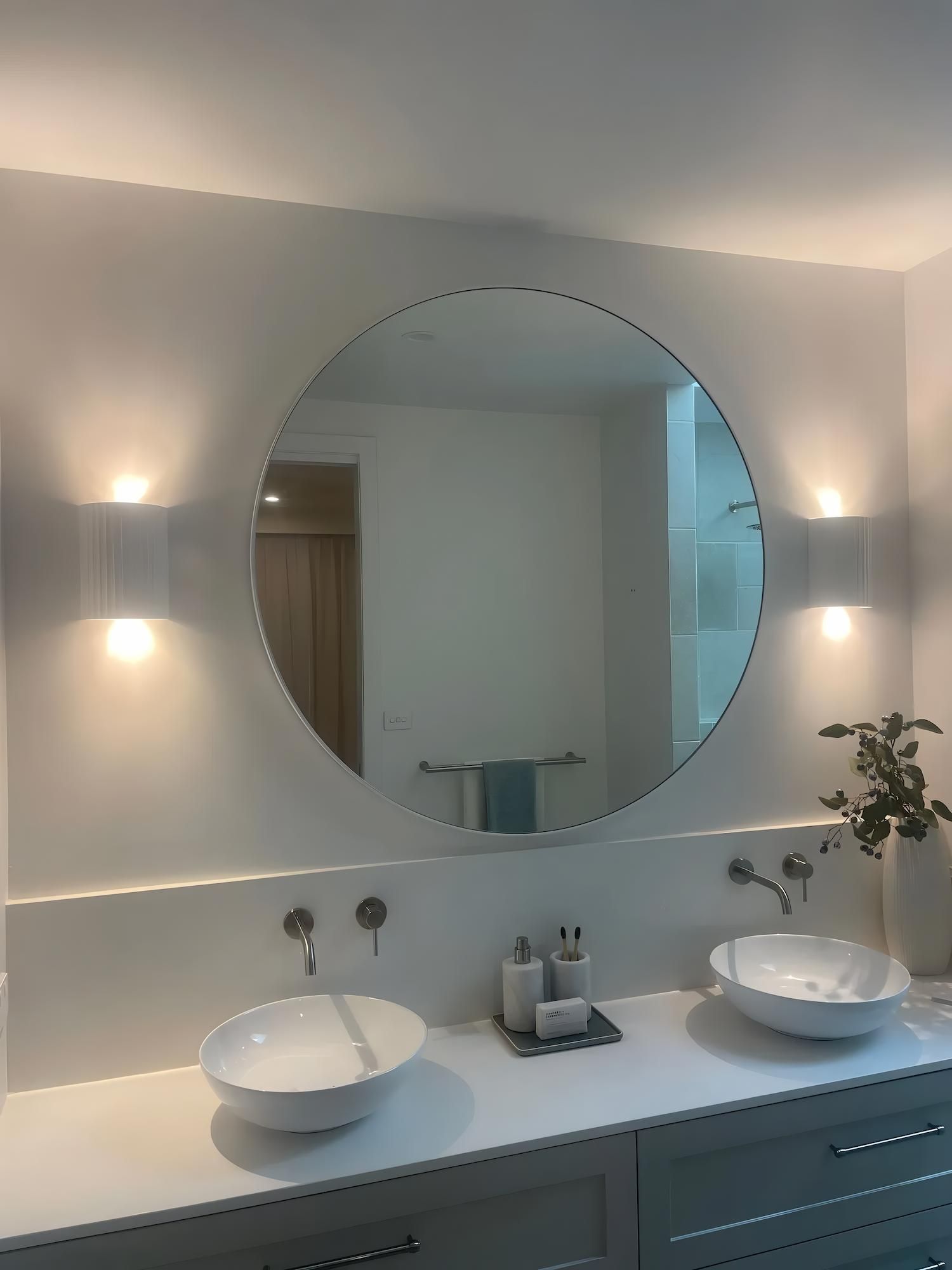 Modern Bathroom With Round Mirror and Vessel Sinks — Switched On Electrics in Wagga Wagga, NSW