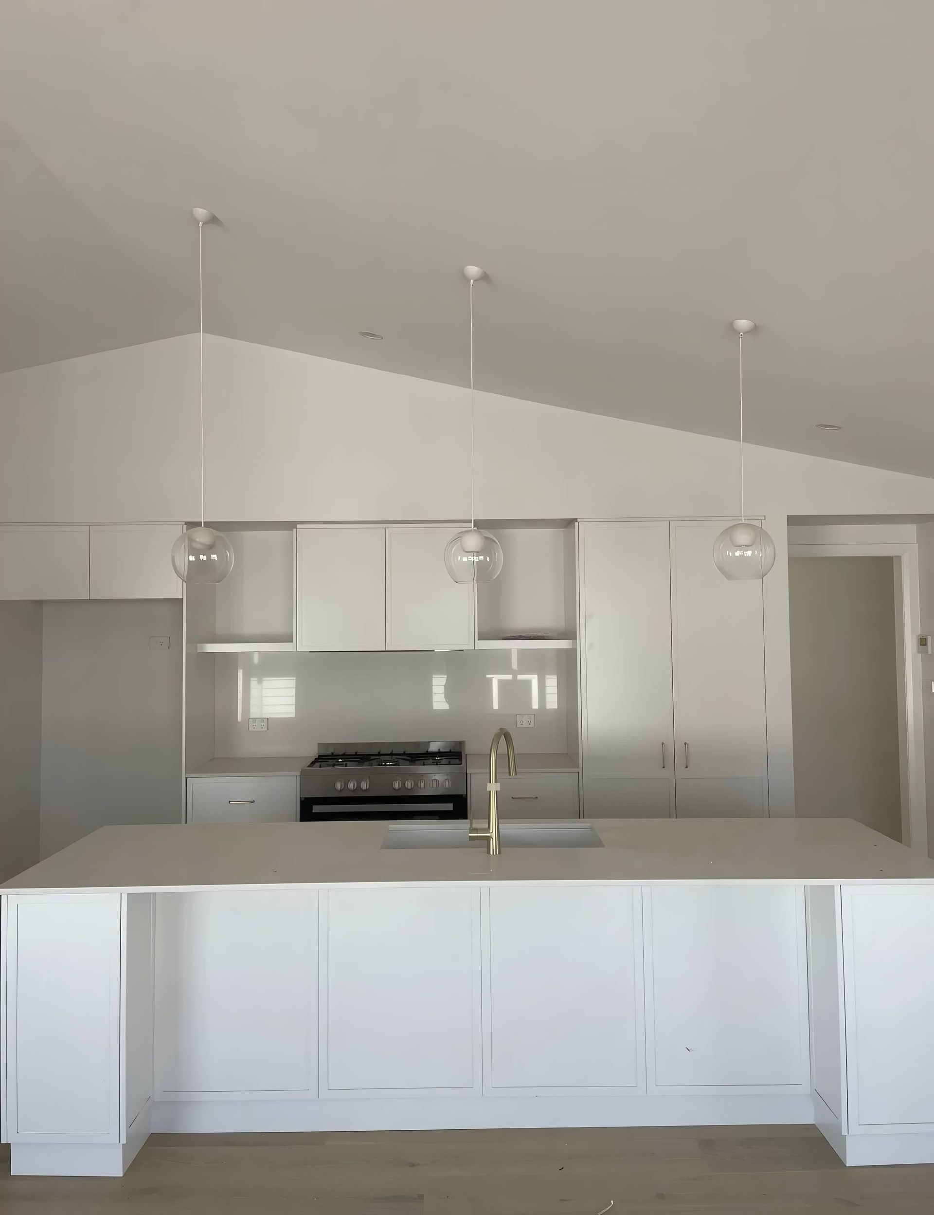 White Kitchen With Island, Cabinets, and Three Pendant Lights — Switched On Electrics in Wagga Wagga, NSW