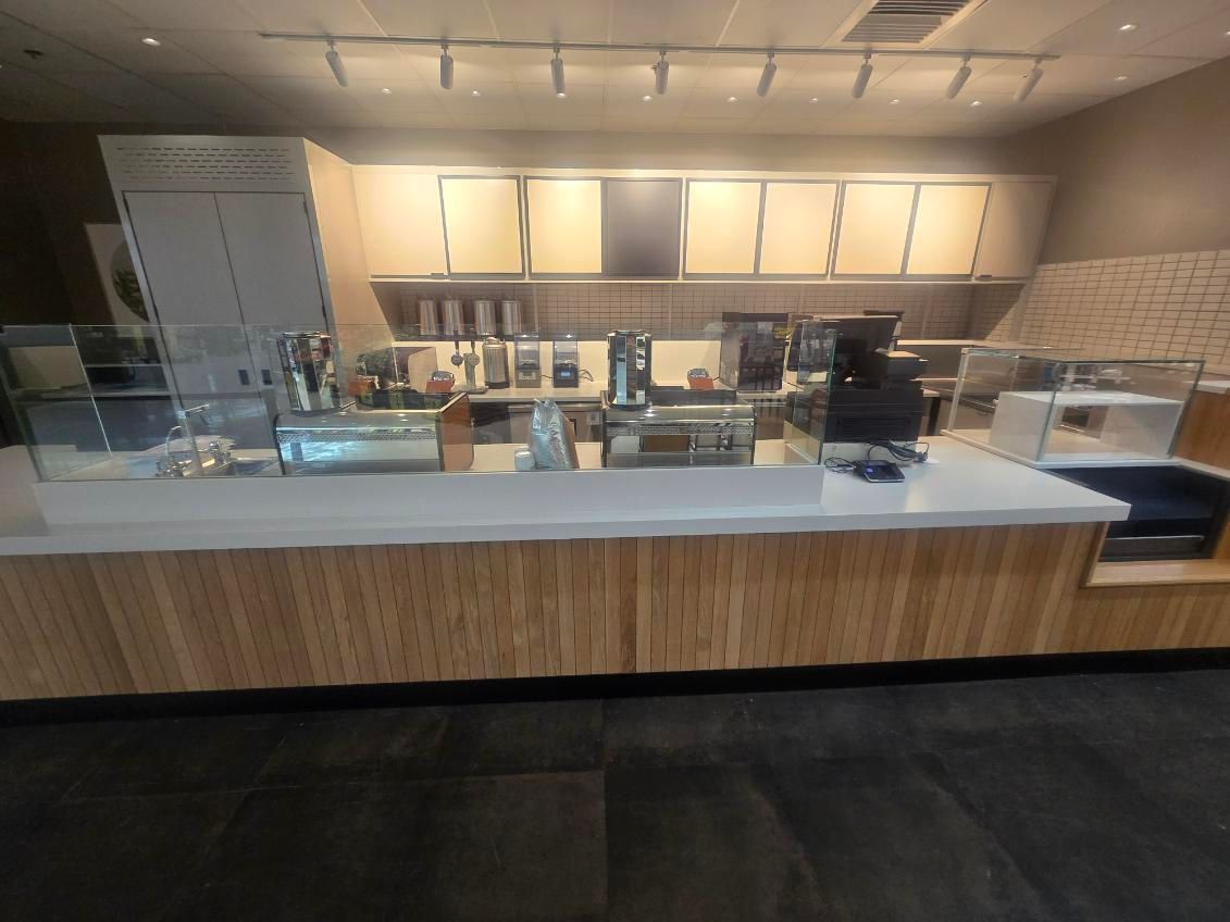 The ceiling of a large warehouse with lots of lights hanging from it.