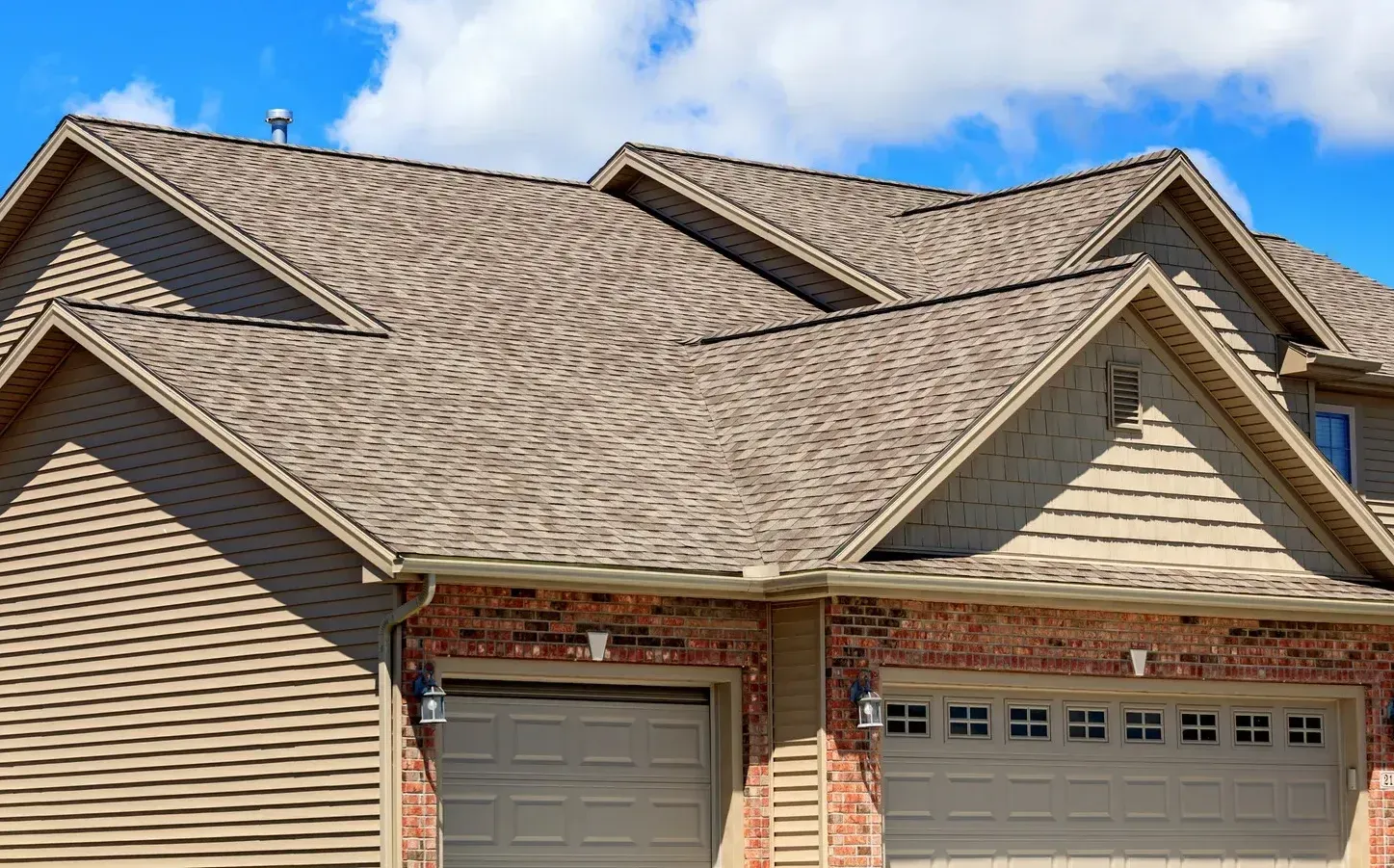 A large house with a roof that has a lot of shingles on it.
