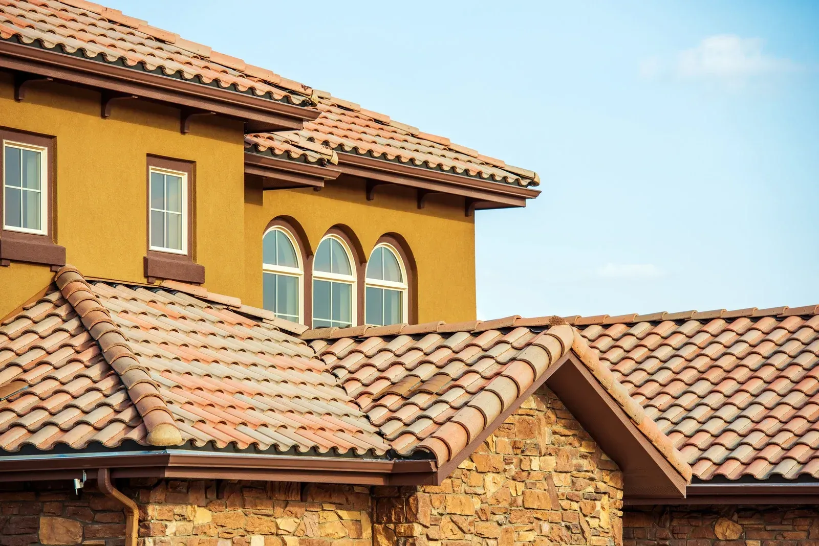 A large house with a tiled roof and arched windows.