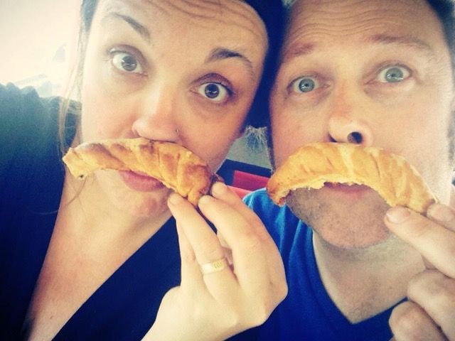 A man and a woman are eating croissants together