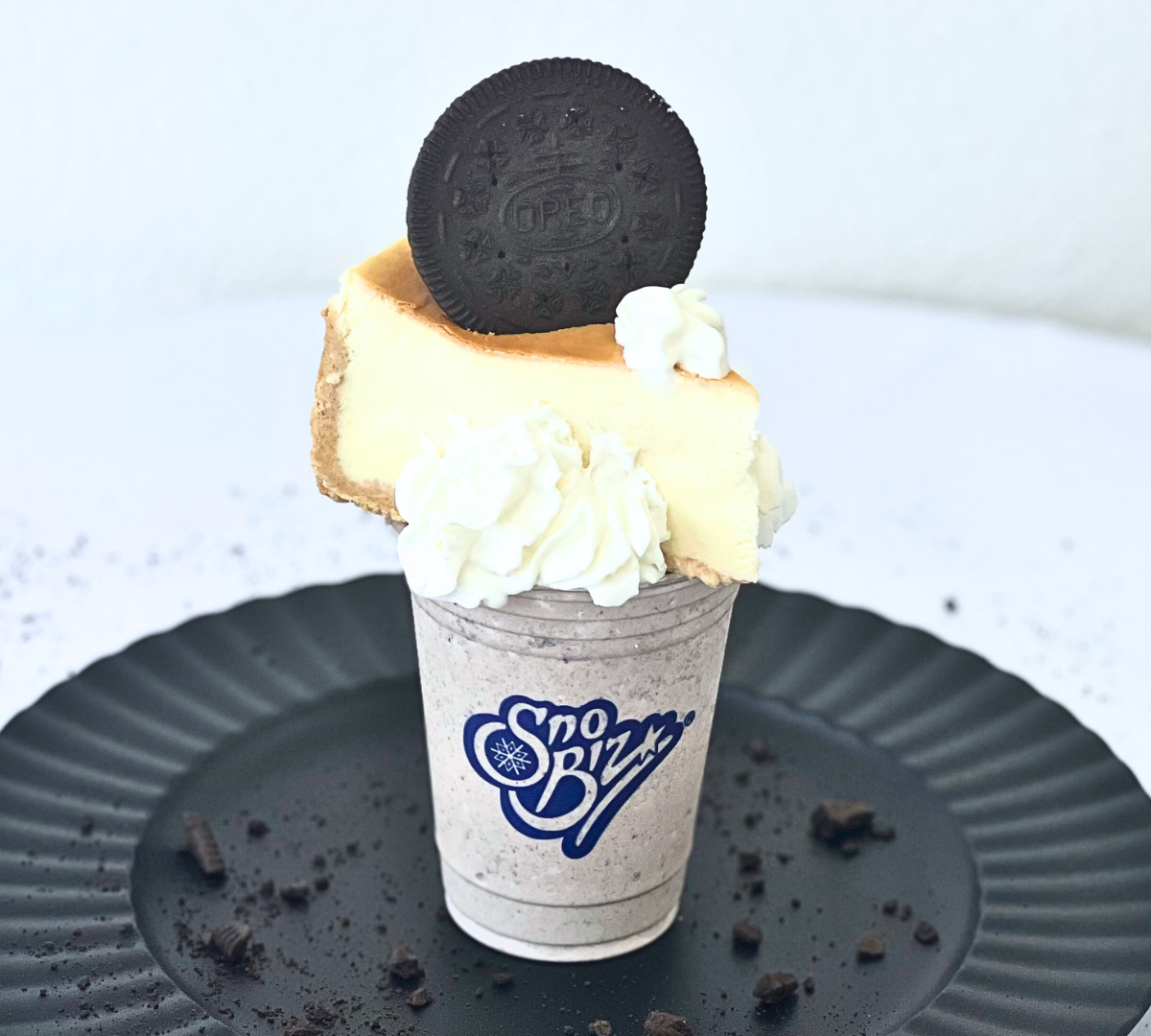 A milkshake with a slice of cheesecake and whipped cream on top.