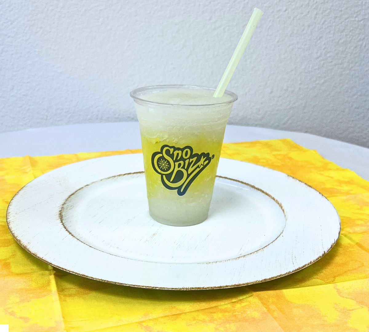 A cup with sno buzz written on it sits on a plate