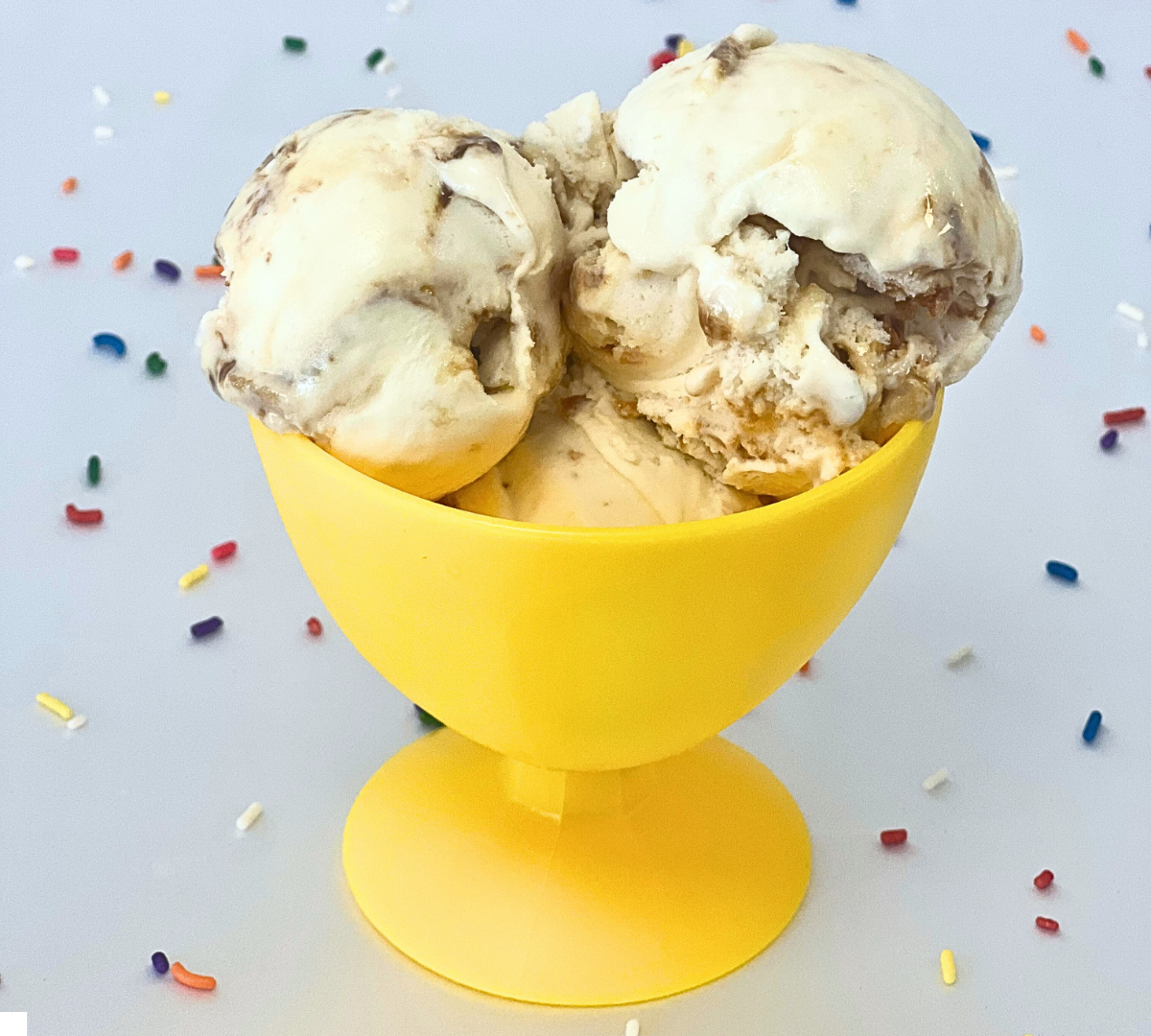 Two scoops of ice cream in a yellow cup