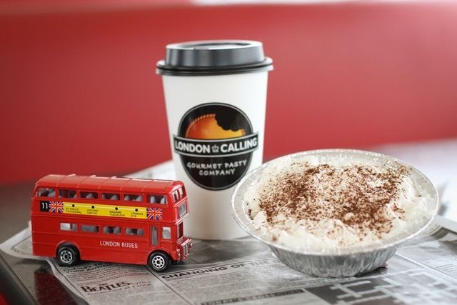 A cup of london & calling coffee next to a pie
