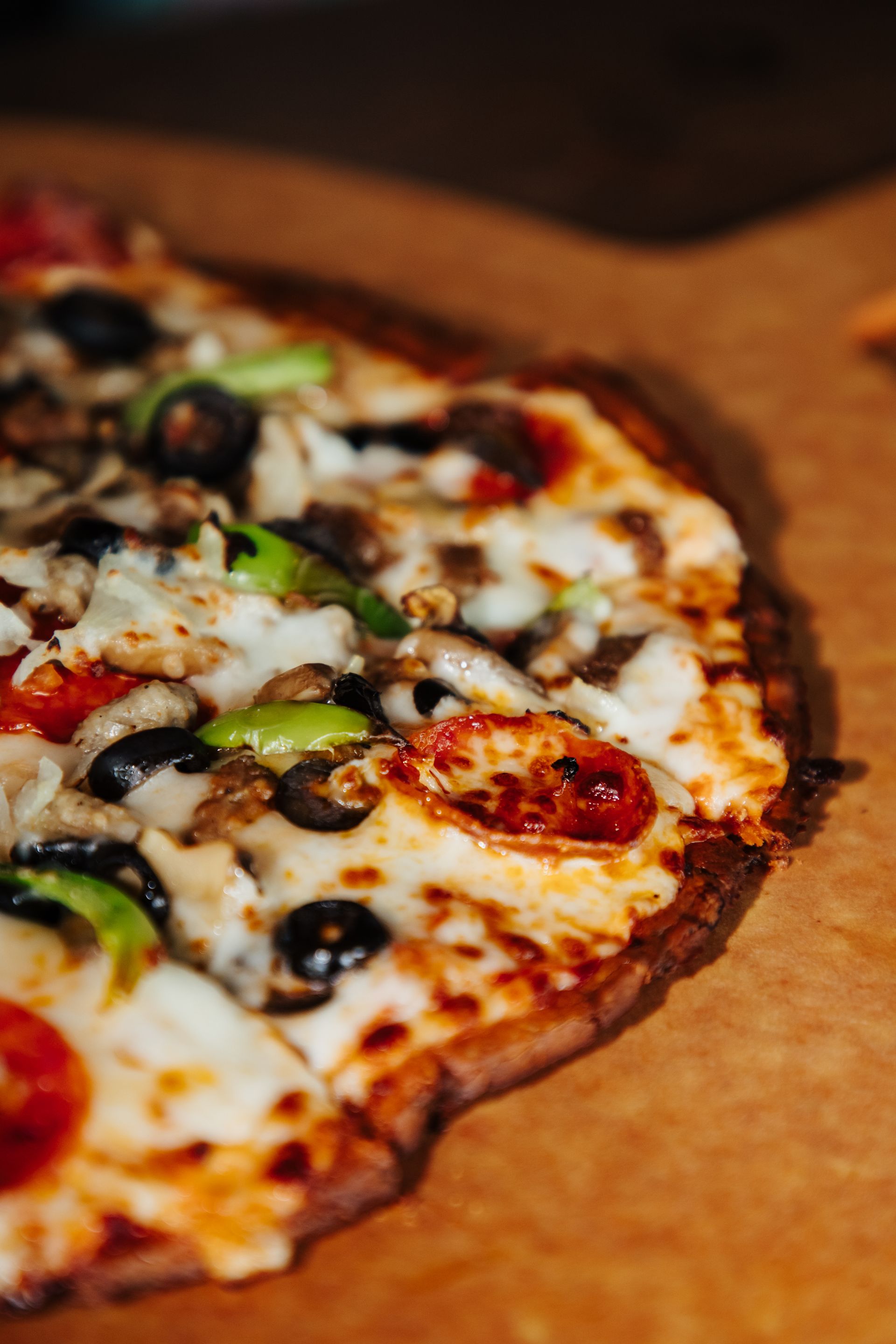 A close up of a pizza with a lot of toppings on a table.