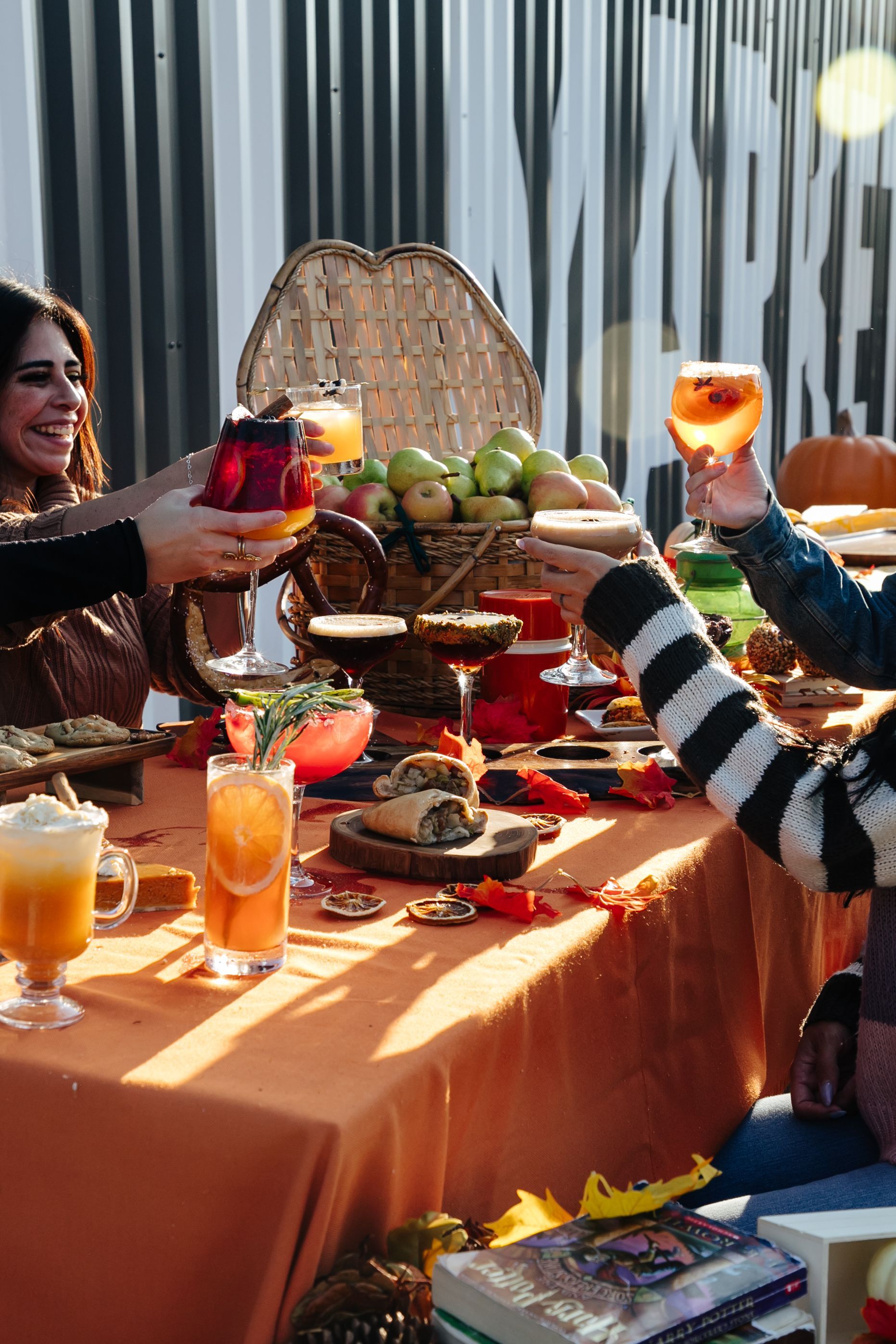 A group of people are sitting at a table toasting with drinks.