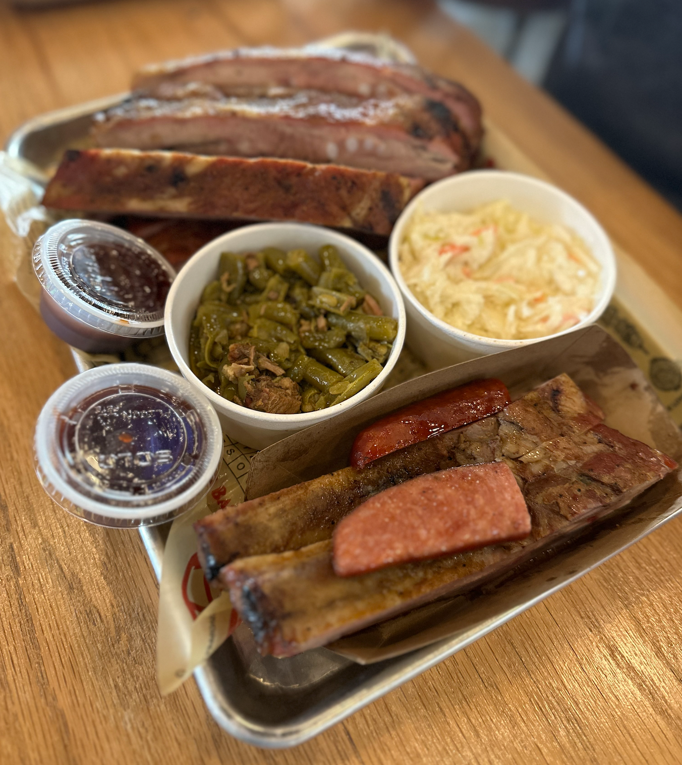 A tray of meat and vegetables on a wooden table.