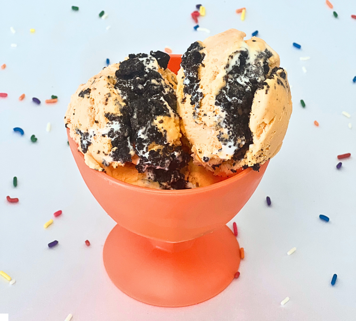 A bowl of ice cream with sprinkles on the table