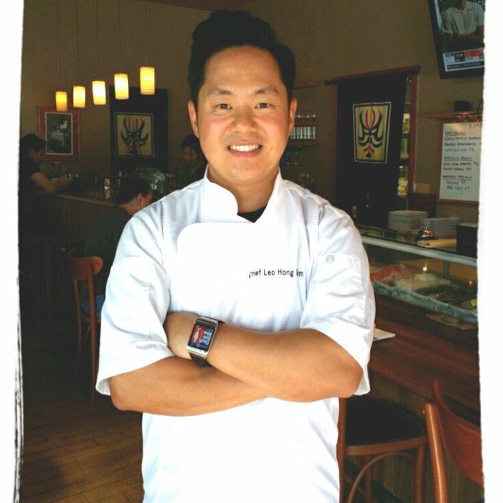 A woman is standing in a kitchen holding a cup of coffee.