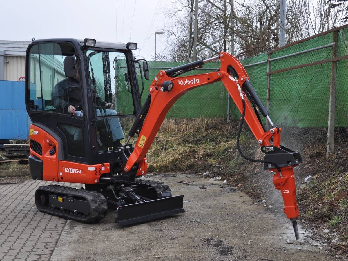 Mini digger and driver breaking concrete