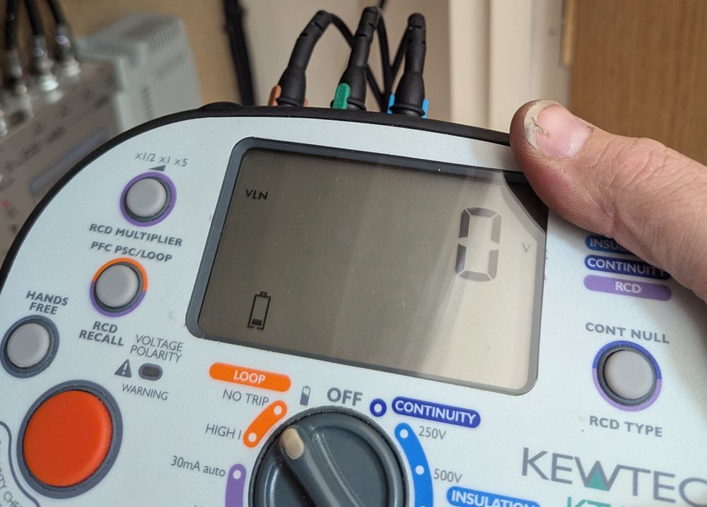 A person holding a KEWTECH KT179 multifunction tester. Display shows 