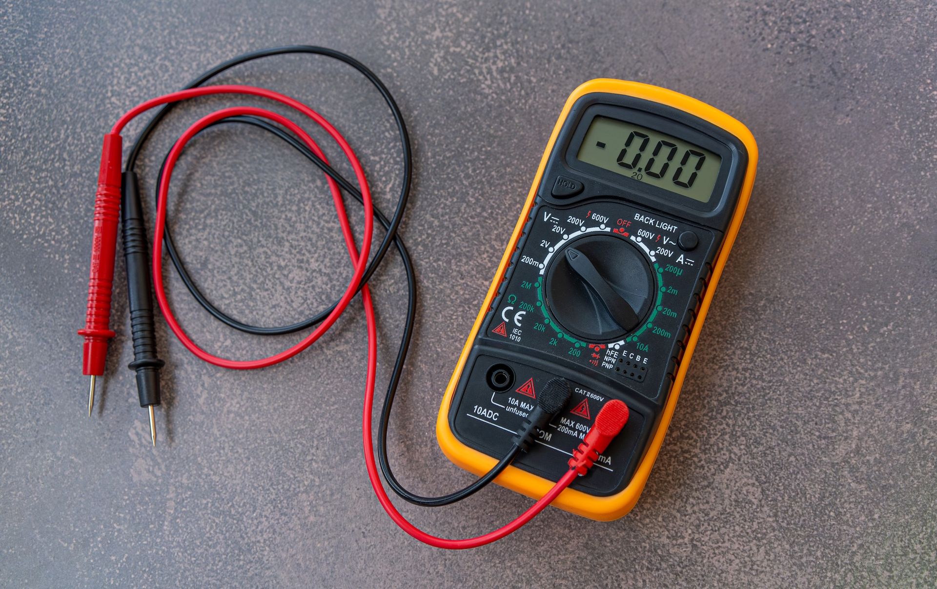 Digital multimeter with red and black probes.