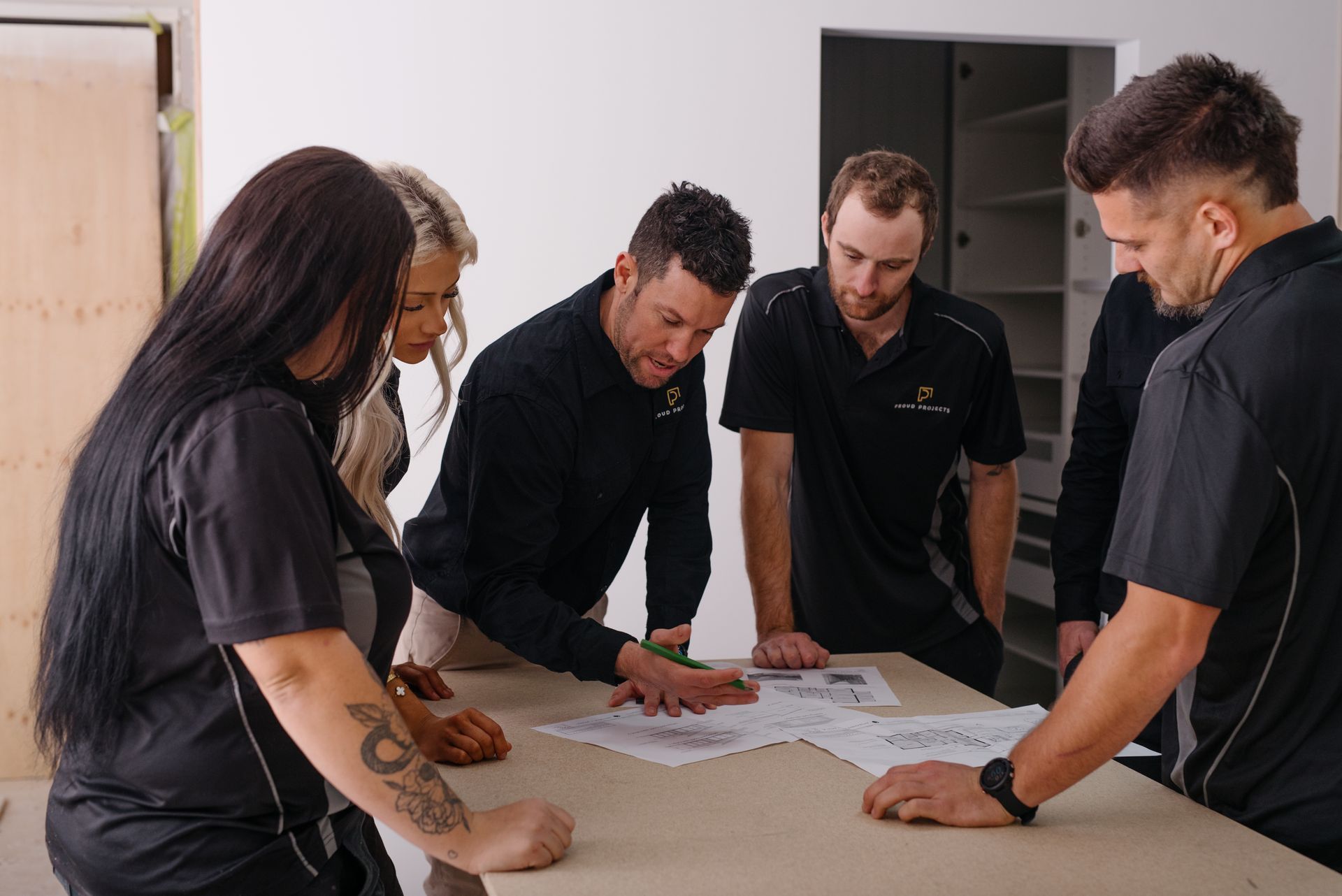 White kitchen with island, wooden floors, and dining table visible in the background.