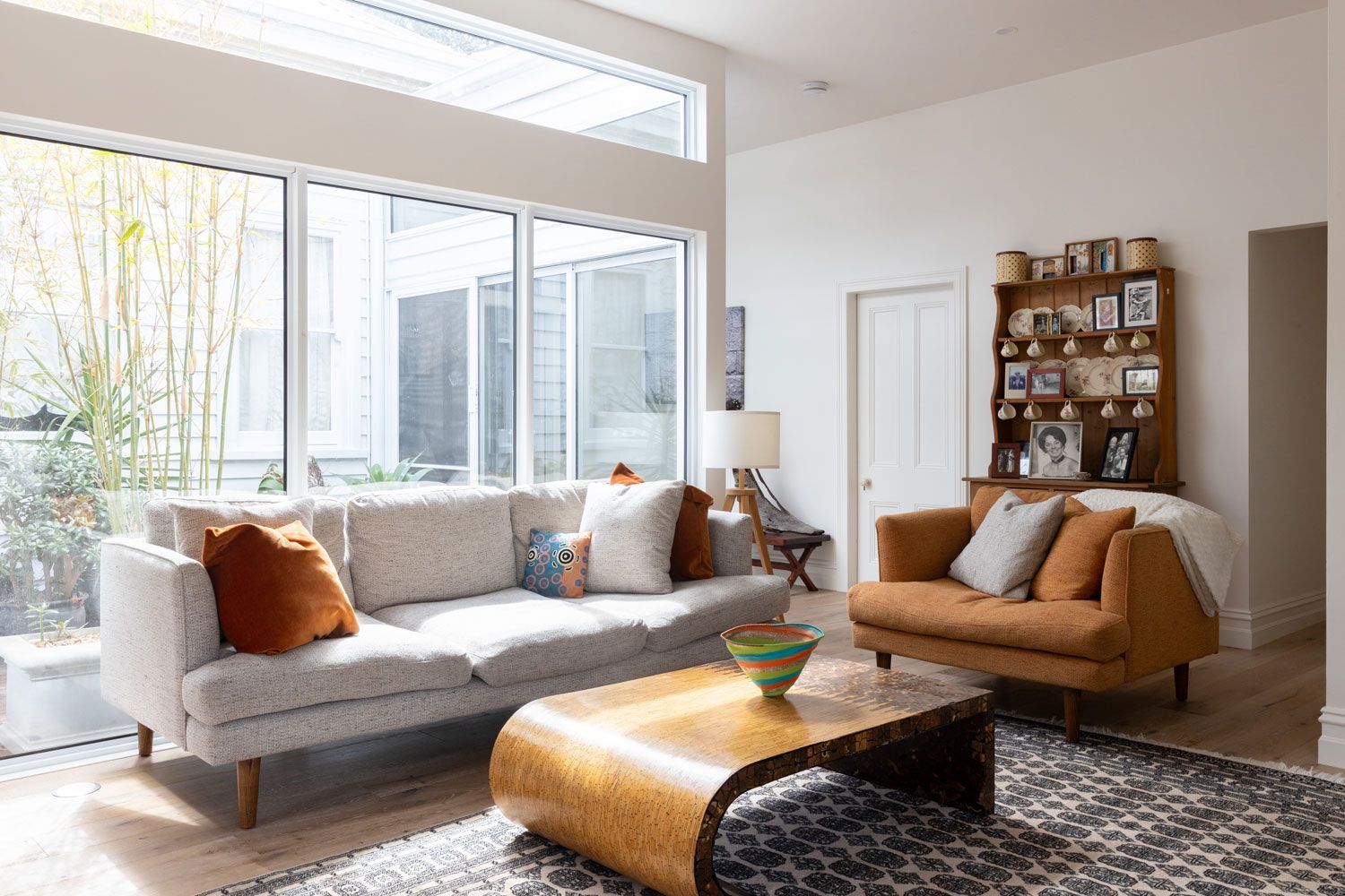Living room with a light gray sofa, orange armchair, and wooden coffee table.