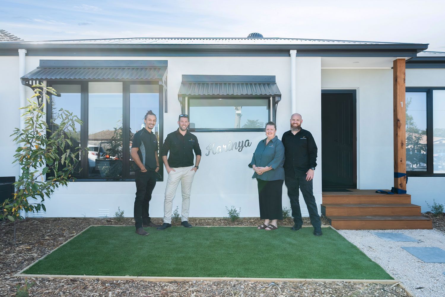 Hallway with black front door, wood paneling, sliding barn door, and framed artwork.