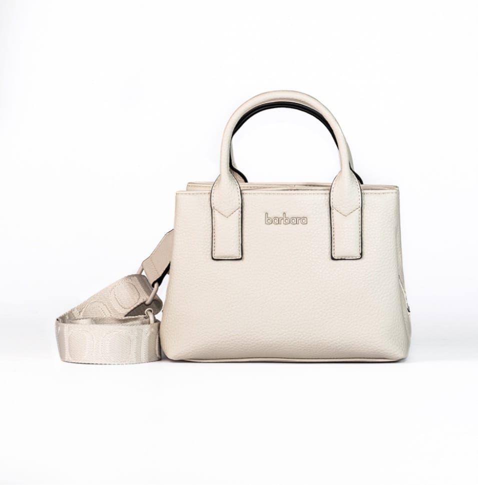 Bolso color crema con asas cortas y bandolera. Luce la inscripción