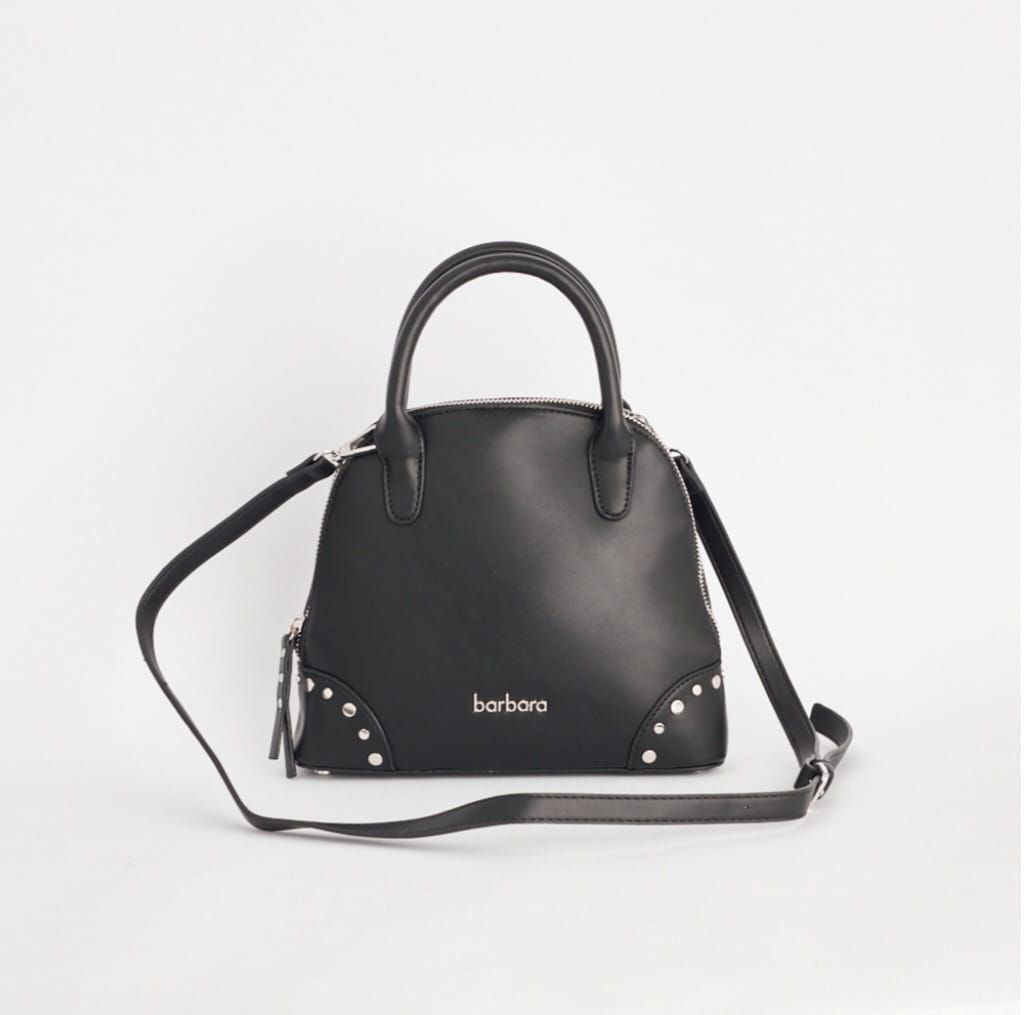 Bolso de mano negro en forma de cúpula con asa superior y correa para el hombro; detalle de tachuelas plateadas y cremallera.