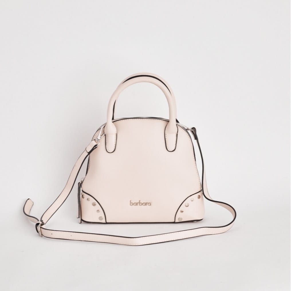 Bolso de mano de color rosa claro con asas y bandolera sobre fondo blanco.