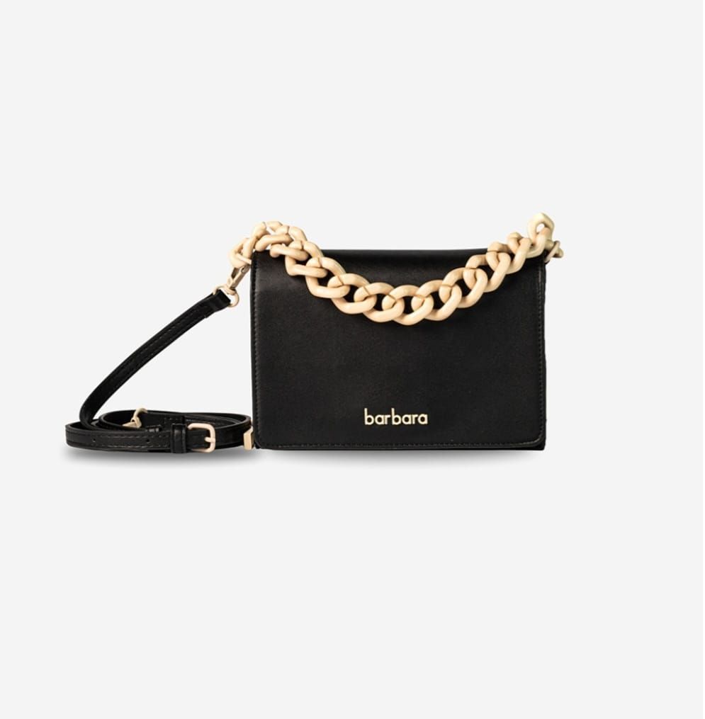 Bolso negro con correa de cadena dorada y correa cruzada negra.
