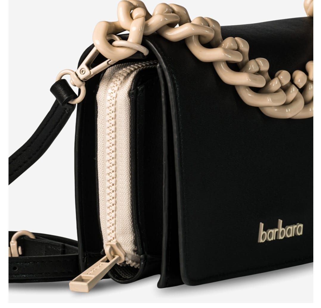 Bolso negro con correa de cadena dorada y correa cruzada negra.