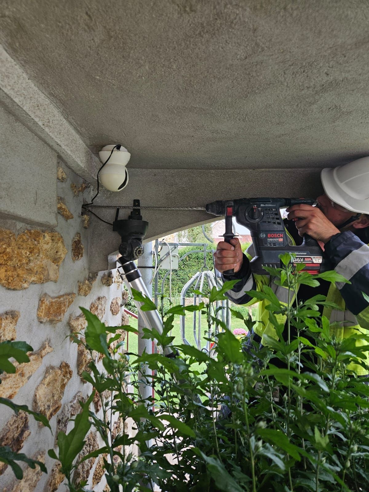Un homme utilise une perceuse pour percer un trou dans un mur.