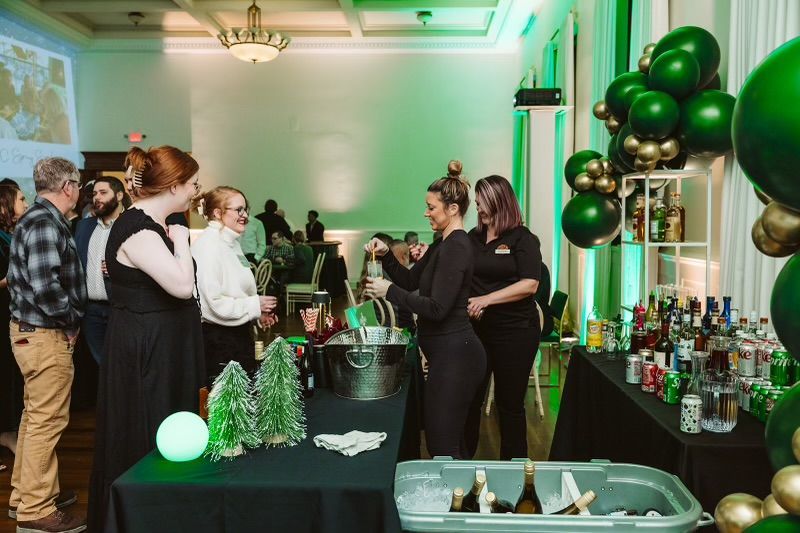A Group of People Are Standing Around a Table in A Room - Lee’s Summit, MO - Top Shelf Bartending Services, LLC