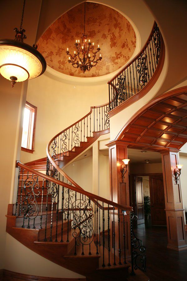 A spiral staircase with a chandelier hanging from the ceiling
