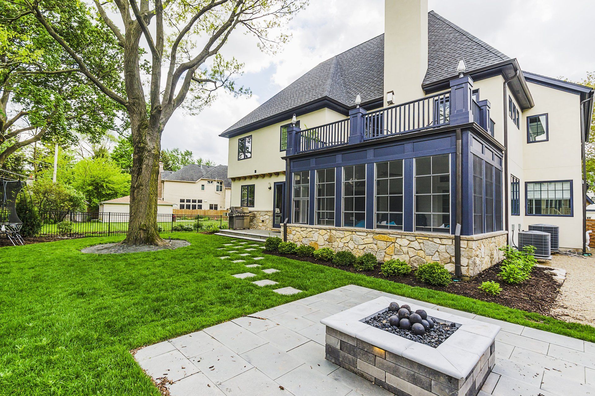 A large house with a fire pit in front of it.