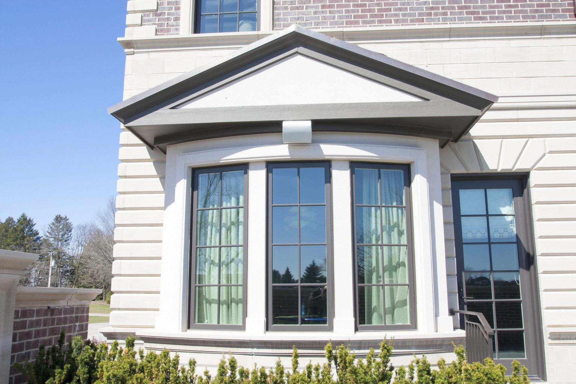 A house with a large bay window on the side of it.