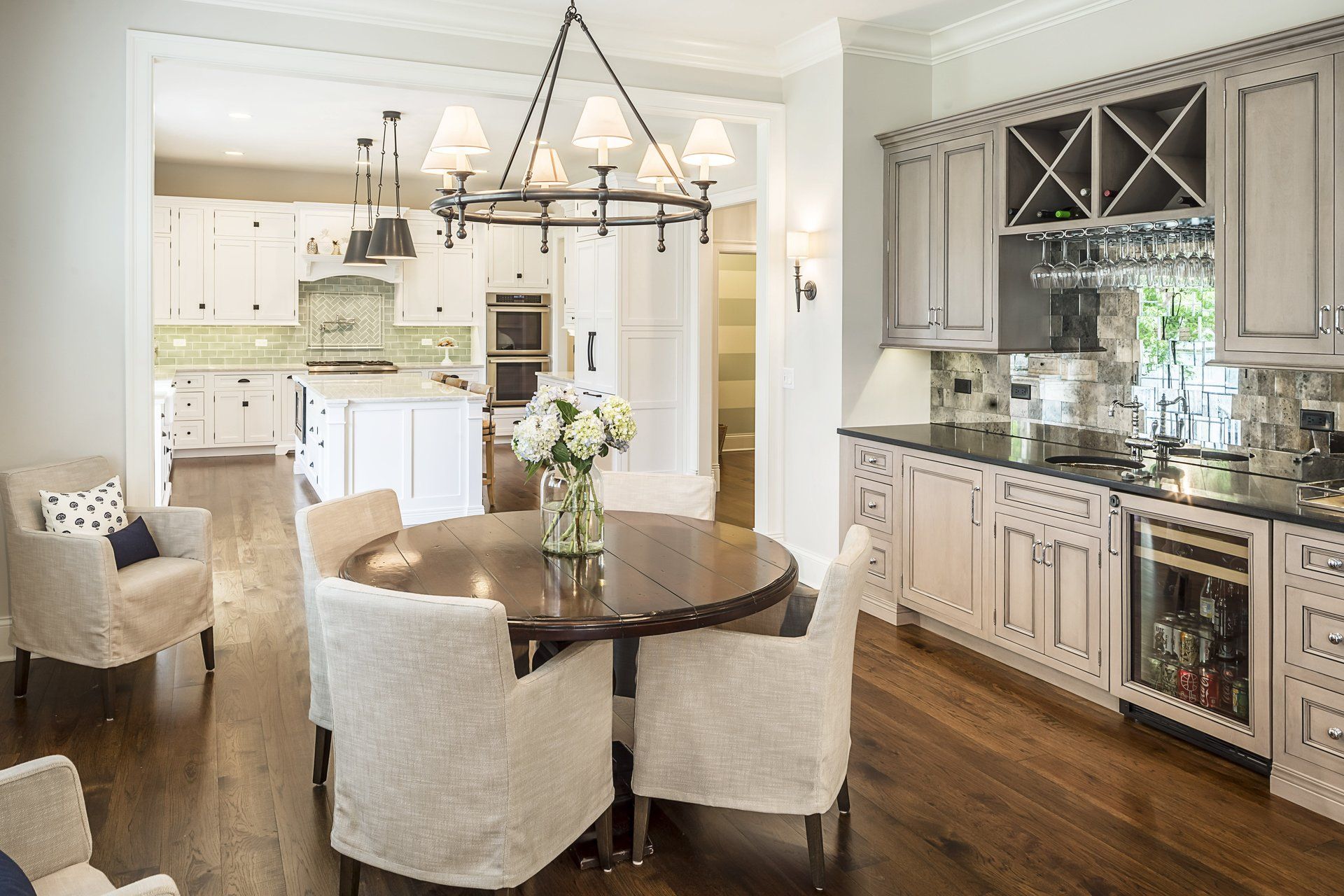 A kitchen with a round table and chairs and a chandelier.