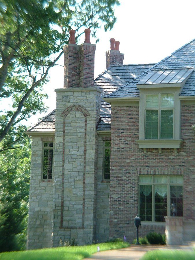 A large brick house with two chimneys on the roof