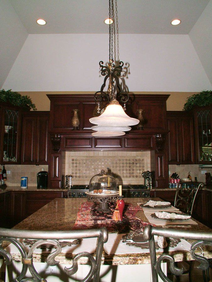A kitchen with a large island and a chandelier hanging from the ceiling