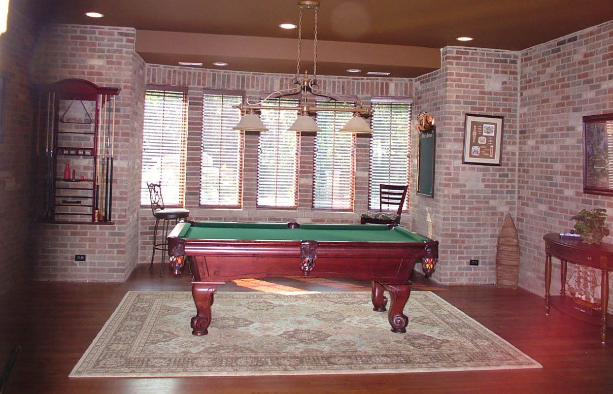 A pool table in a room with a brick wall