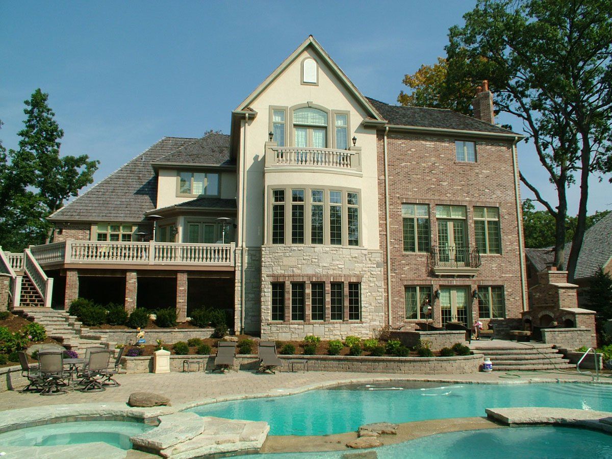 A large house with a swimming pool in front of it
