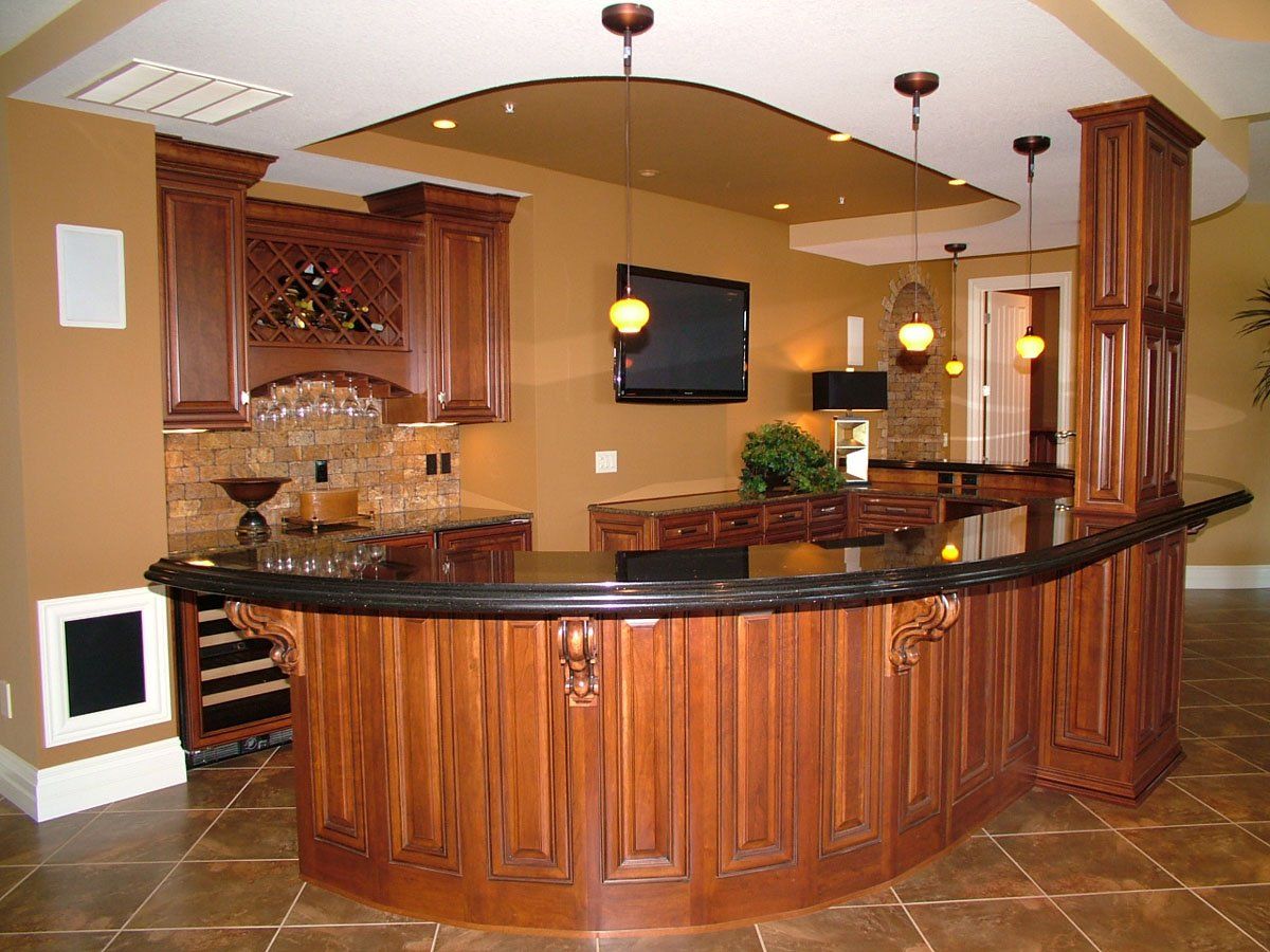 A kitchen with a curved bar and a flat screen tv