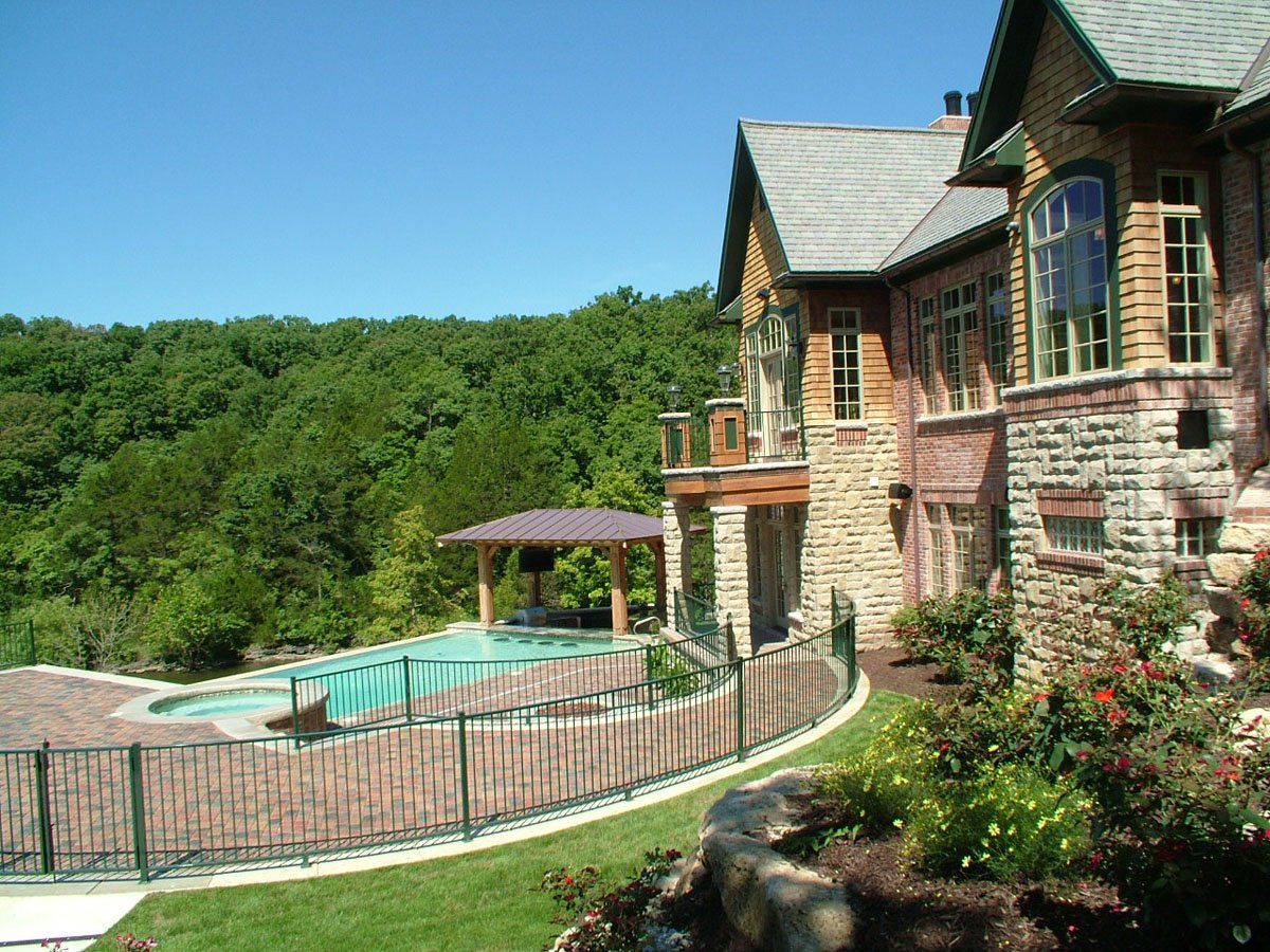 A large house with a swimming pool in front of it