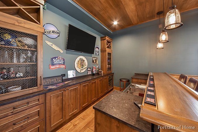 A kitchen with a bar and a television on the wall.