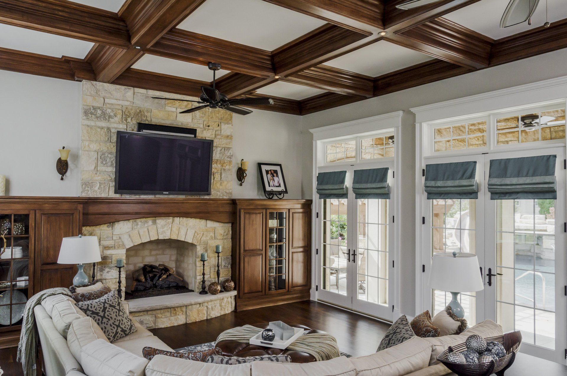 A living room with a fireplace , couch , television and ceiling fan.