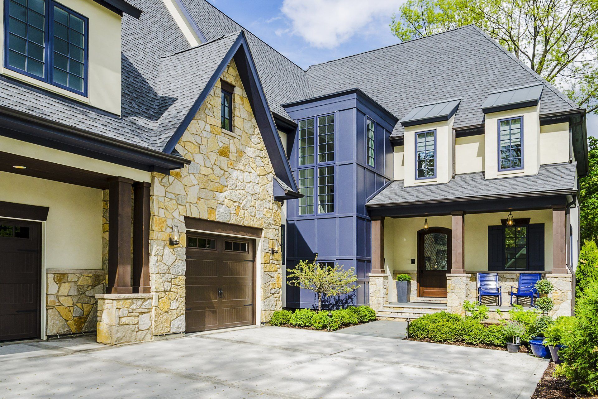 A large white and blue house with a garage and a porch.