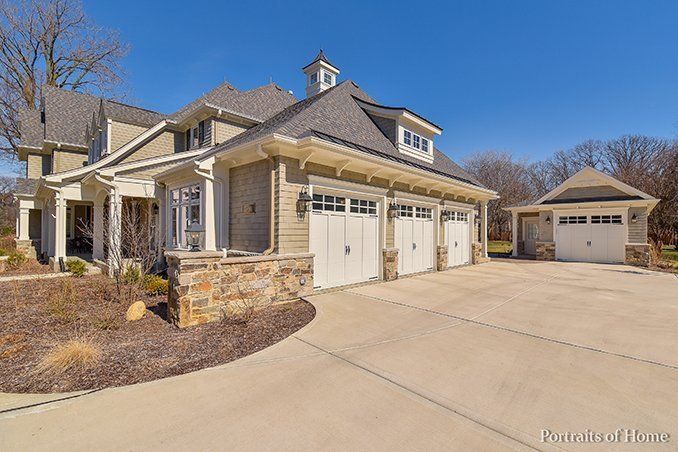 A large house with a lot of garage doors and a driveway.