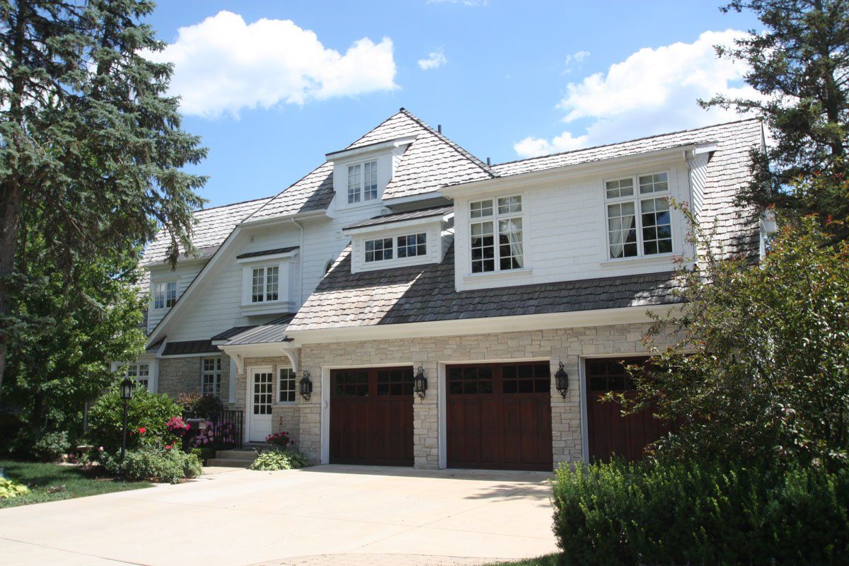 A large white house with two brown garage doors