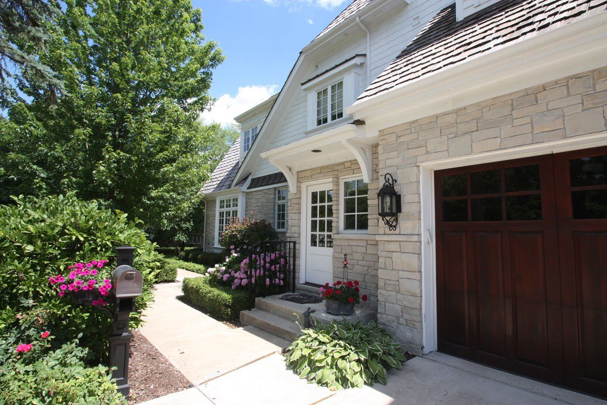 A large white house with a brown garage door